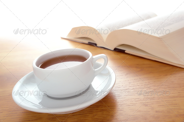 Cup of Coffee and Big Book Leisure on a Wood Table