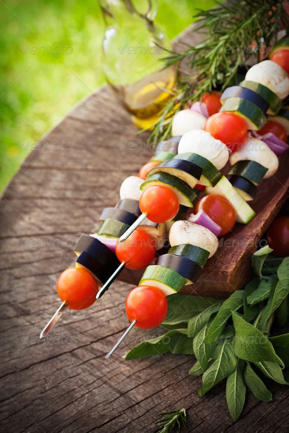 Spring garden barbecue. Vegetable kebabs with cherry tomatoes, zucchini, eggplant on wooden background