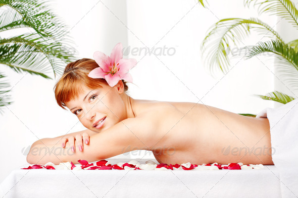 Lady with flower in hair on massage table