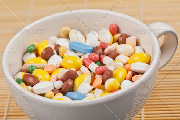 White cup filled with medicine pills