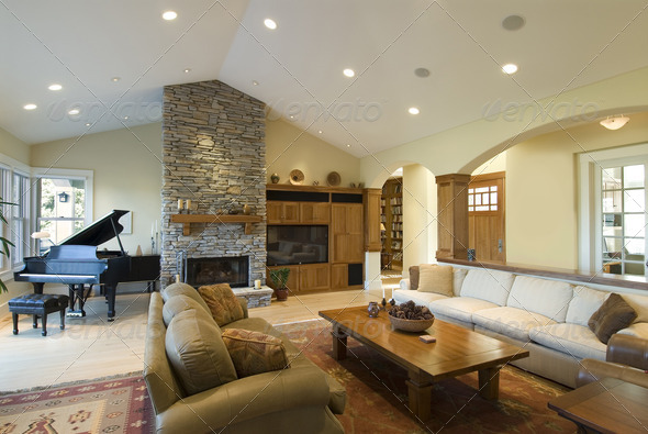 Living room in custom home,stone fireplace,grand piano,big screen,archways,contemporary furnishings