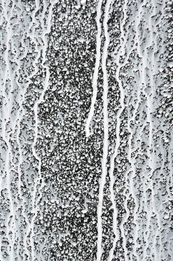 Abstract paint splash. Messy white paint drips on black background.