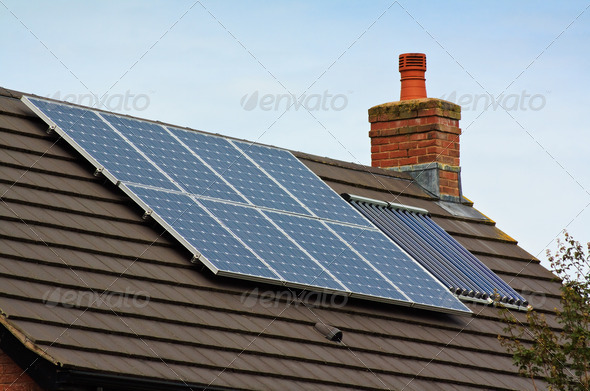 Photovoltaic Solar and central heating panels on tiled roof of residential home