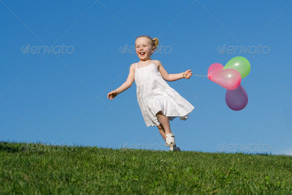happy summer child running outdoors with balloons