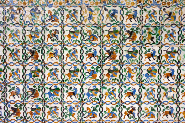 Historic tiled wall with many mythical creatures: satyrs, centaurs, unicorns in Real Alcazar, Seville, Spain, Andalusia region.