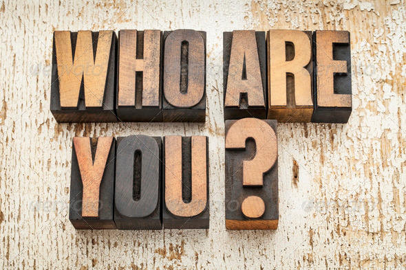 who are you question in vintage letterpress wood type on a grunge painted barn wood background