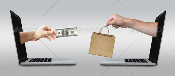 Buying Products Online with cash. Hands reach of laptops