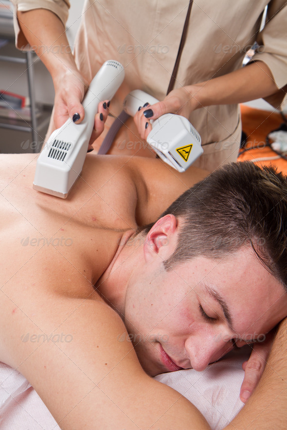 young man receiving laser epilation on beauty center