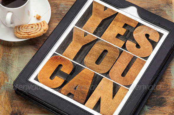 Yes you can – motivational slogan on a digital tablet with a cup of coffee