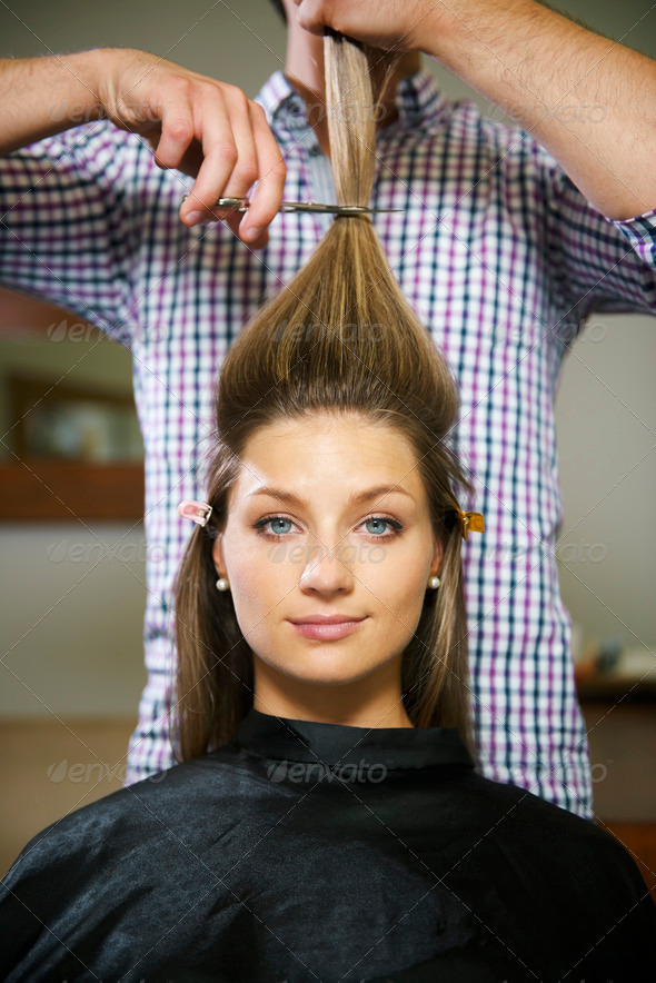 female client in hairdresser shop happy about cutting long hair and looking at camera