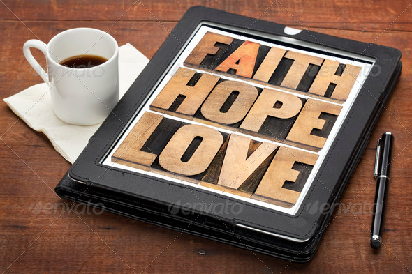faith, hope and love – a collage of words in vintage letterpress wood type on a digital tablet with a cup of coffee