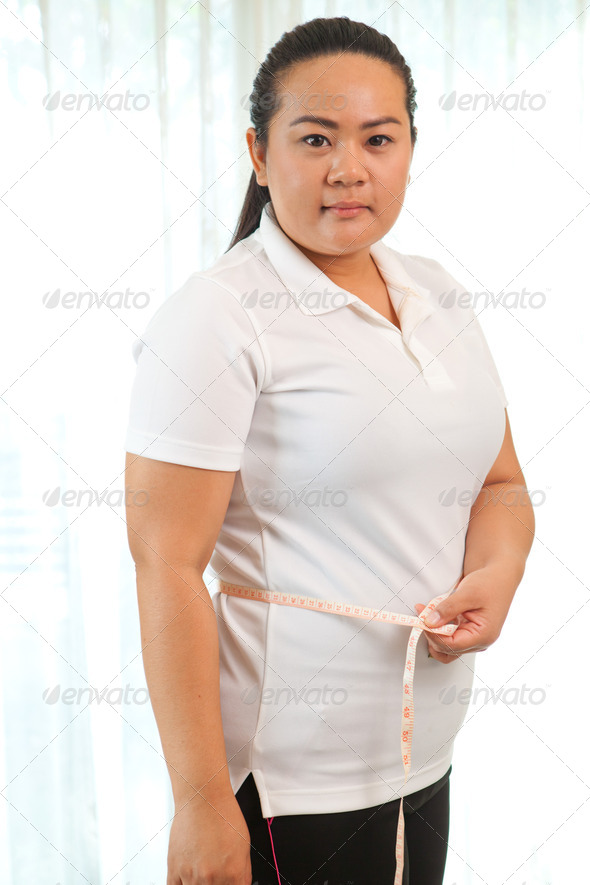 fat asian woman measuring her stomach