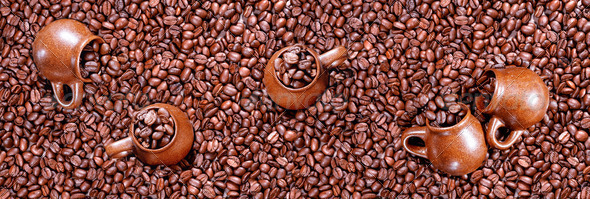 Panorama of roasted coffee beans and cups.