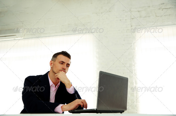 handsome businessman working on a laptop at office