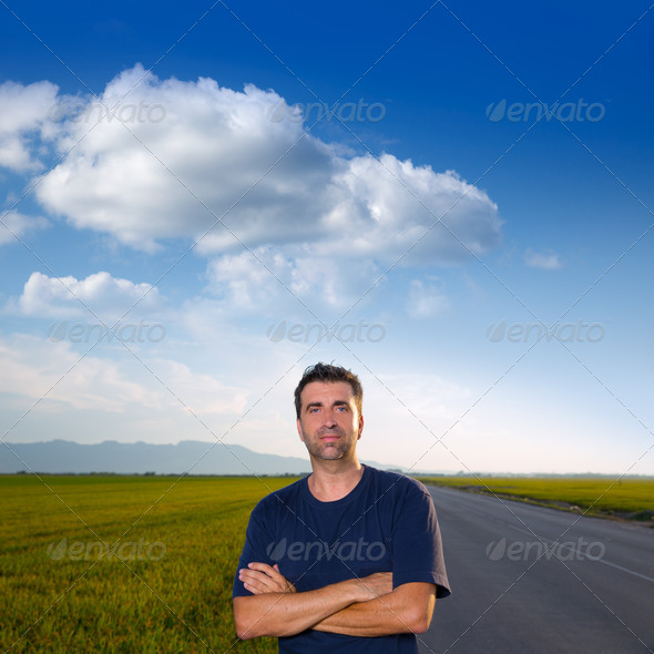 Mid age man in road at meadows posing crossed arms